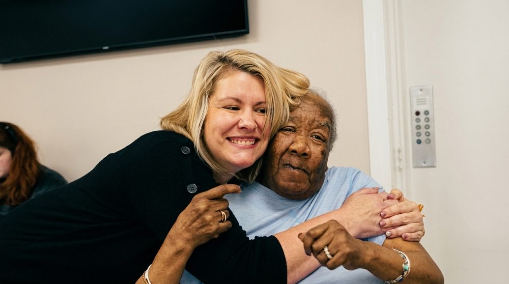 A Five Oaks team member hugging a resident